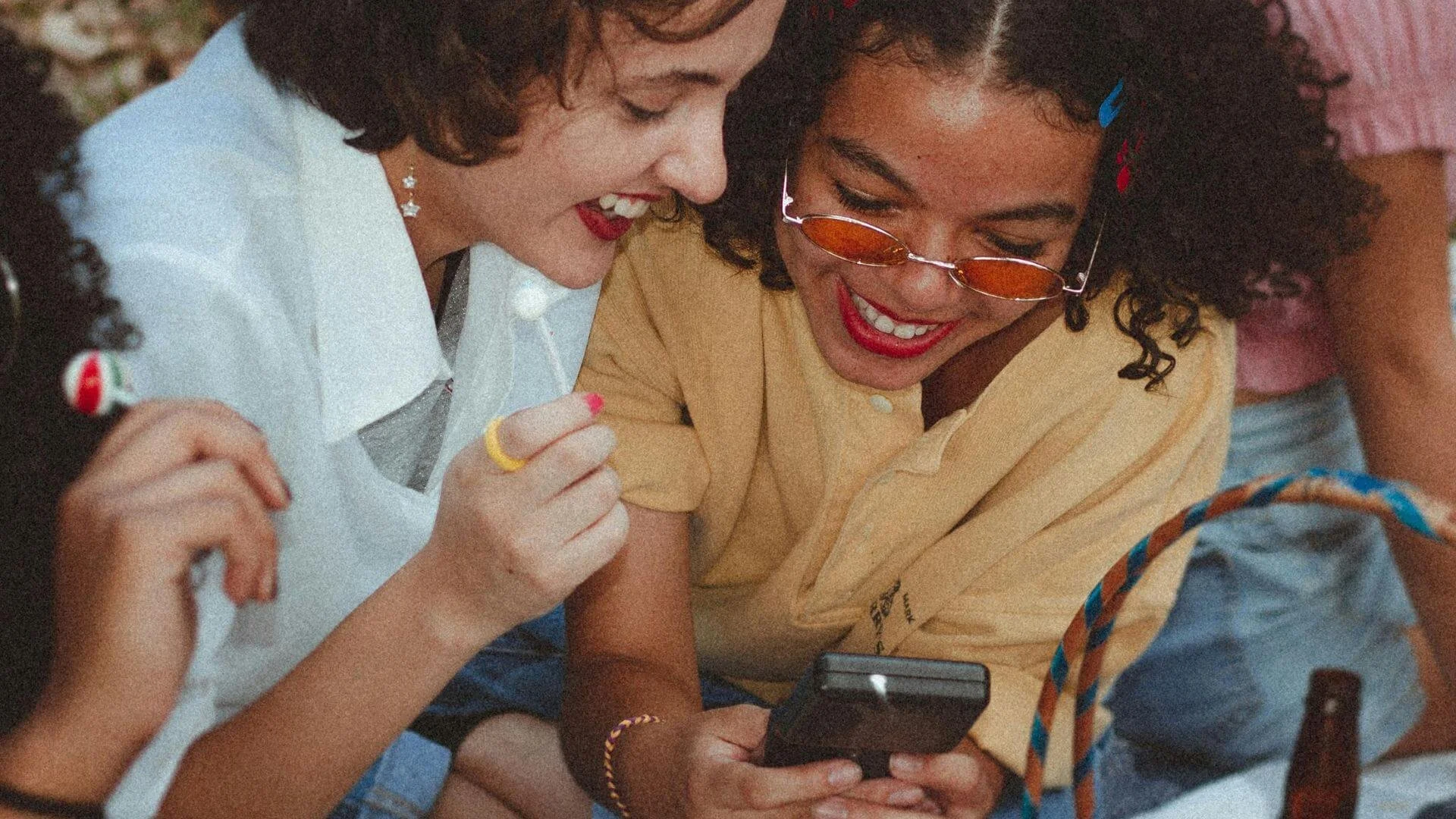Group of friends smiling while looking at the phone