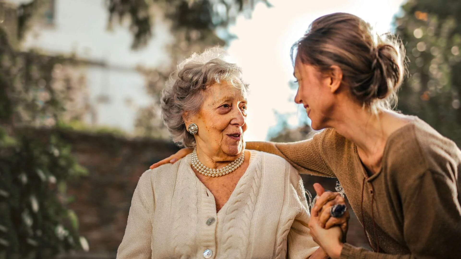 A woman and an old woman smiling to each other