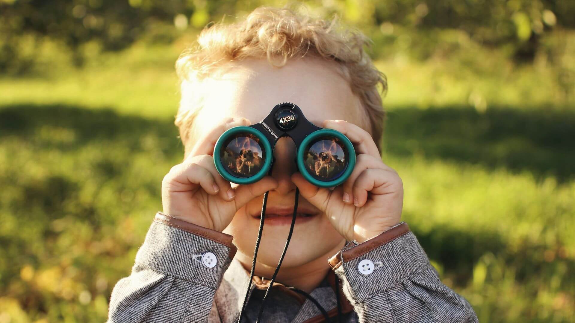 Kid looking through a binocular