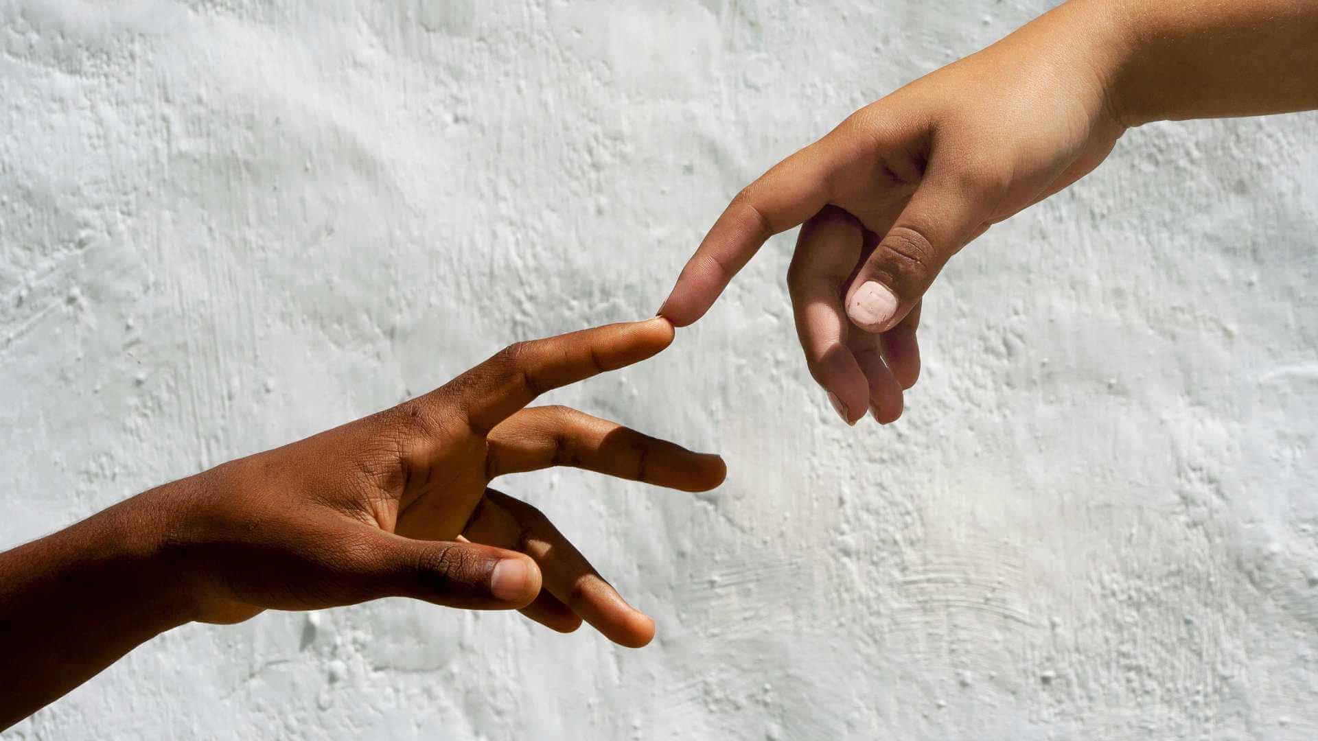 Two hands reaching toward each other, nearly touching
