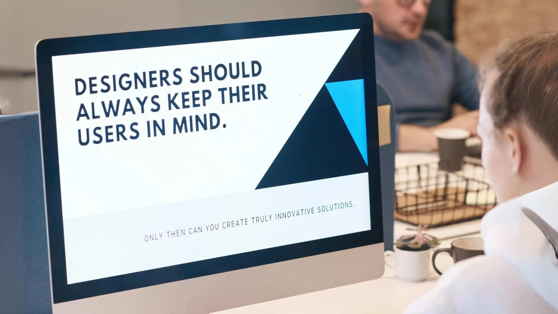 Text on a monitor stating 'Designers should always keep their users in mind.