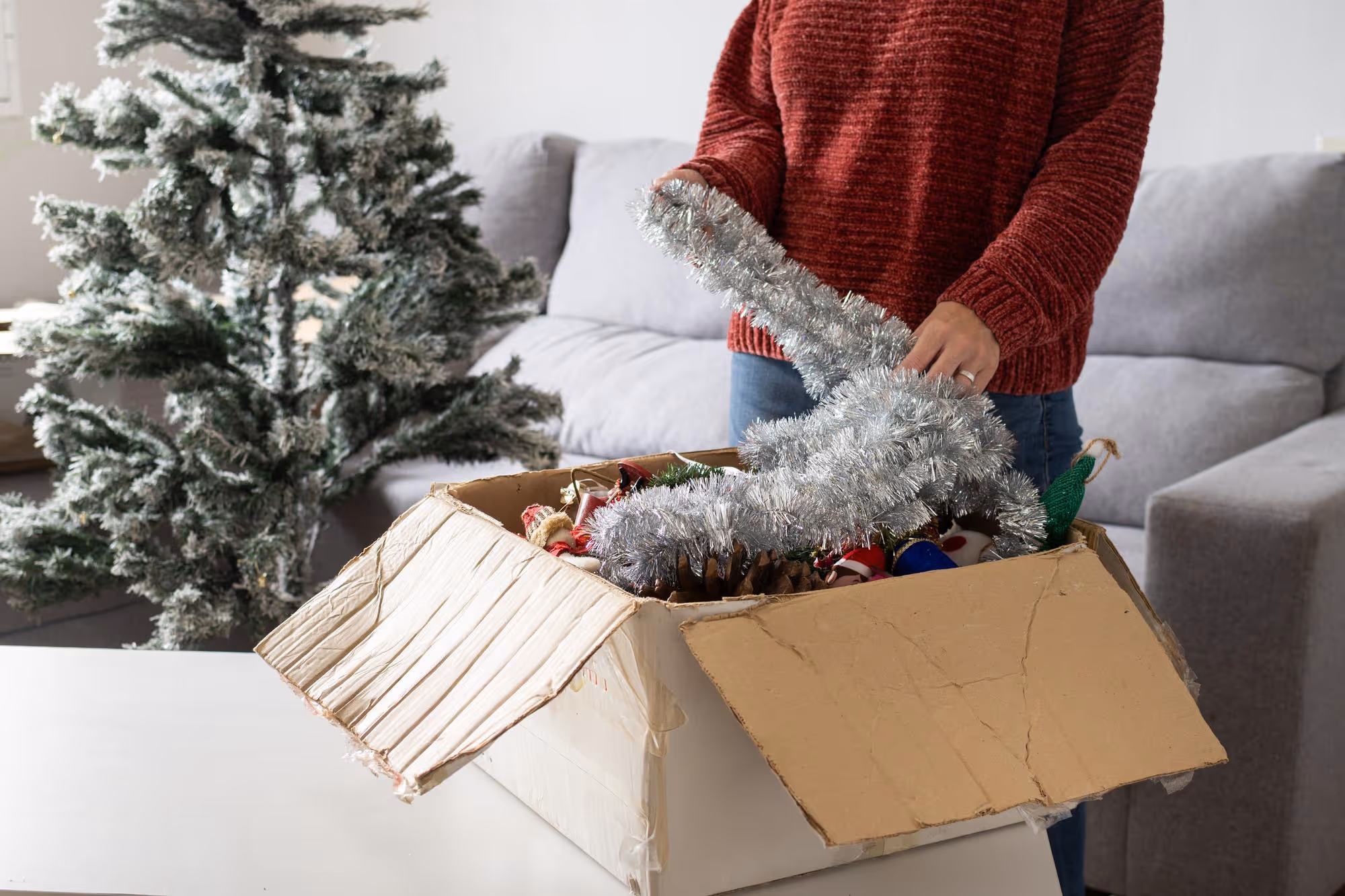 A woman packing up Christmas items into a box