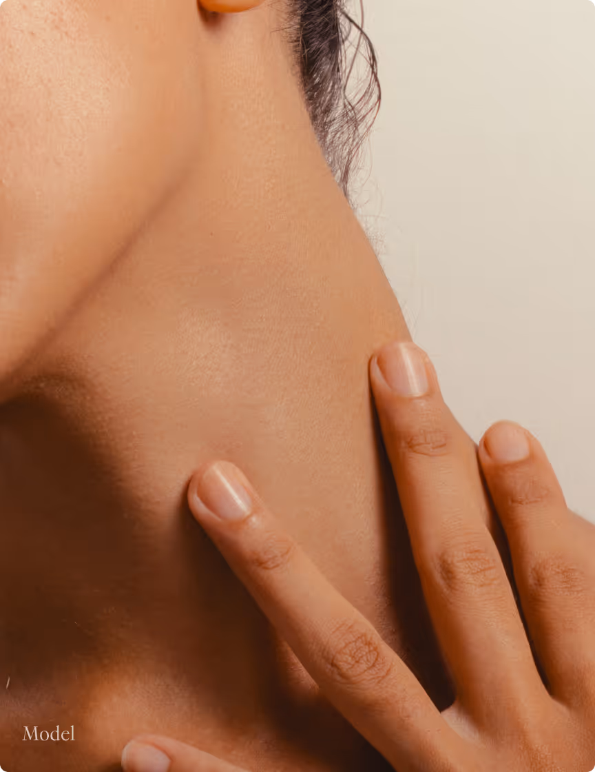 Close-up of a person's neck with fingers gently touching the skin.