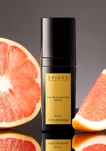 Black bottle of Epione Beverly Hills Eye Rejuvenation Serum with grapefruit halves on a reflective surface.