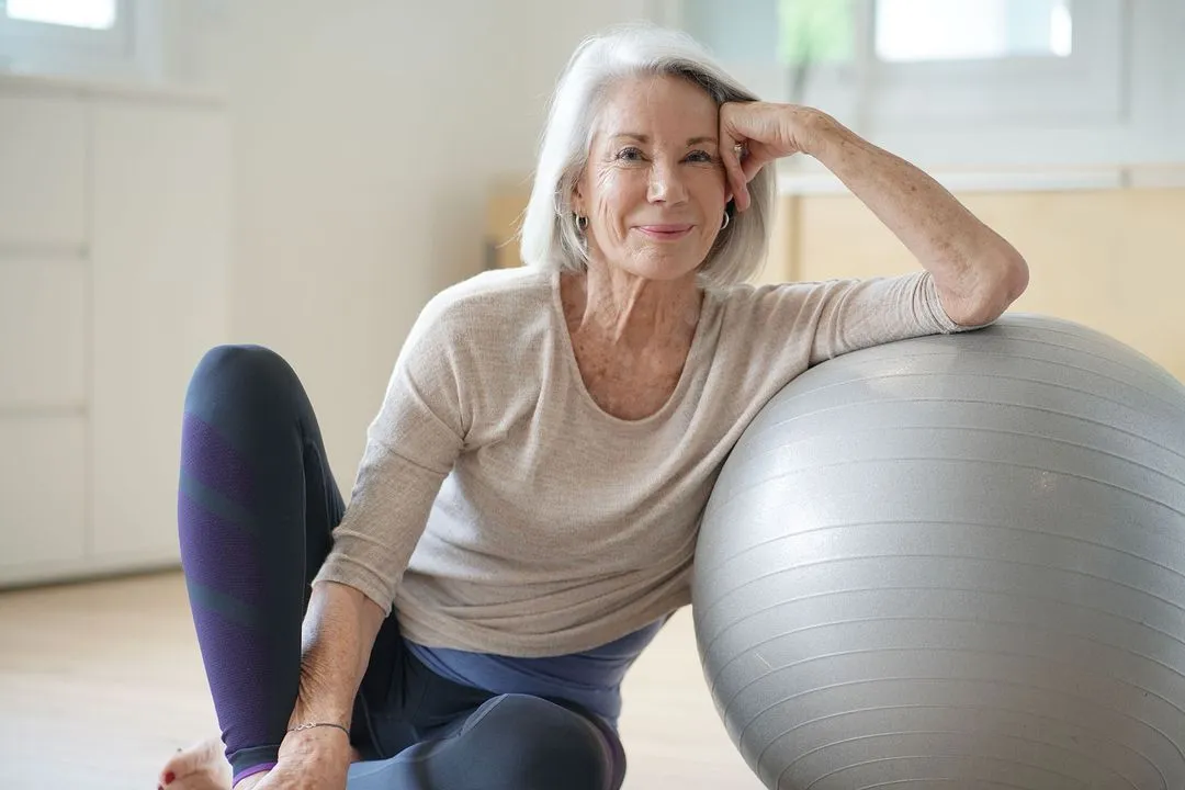 Woman sitting with a yoga ball