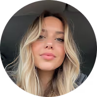 Portrait of a young woman with long blonde hair and light makeup inside a car.