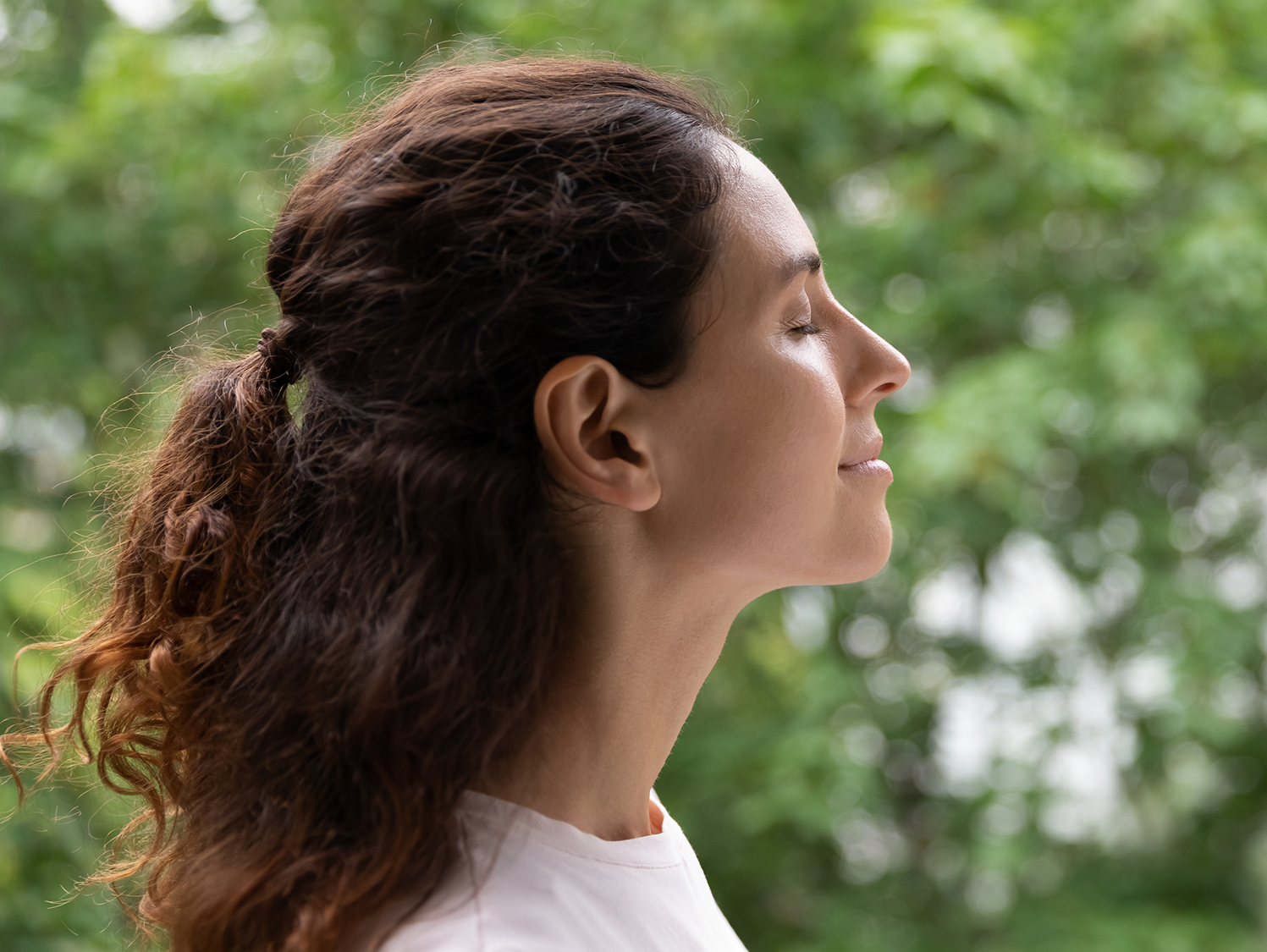 A woman with her eyes closed looking up.