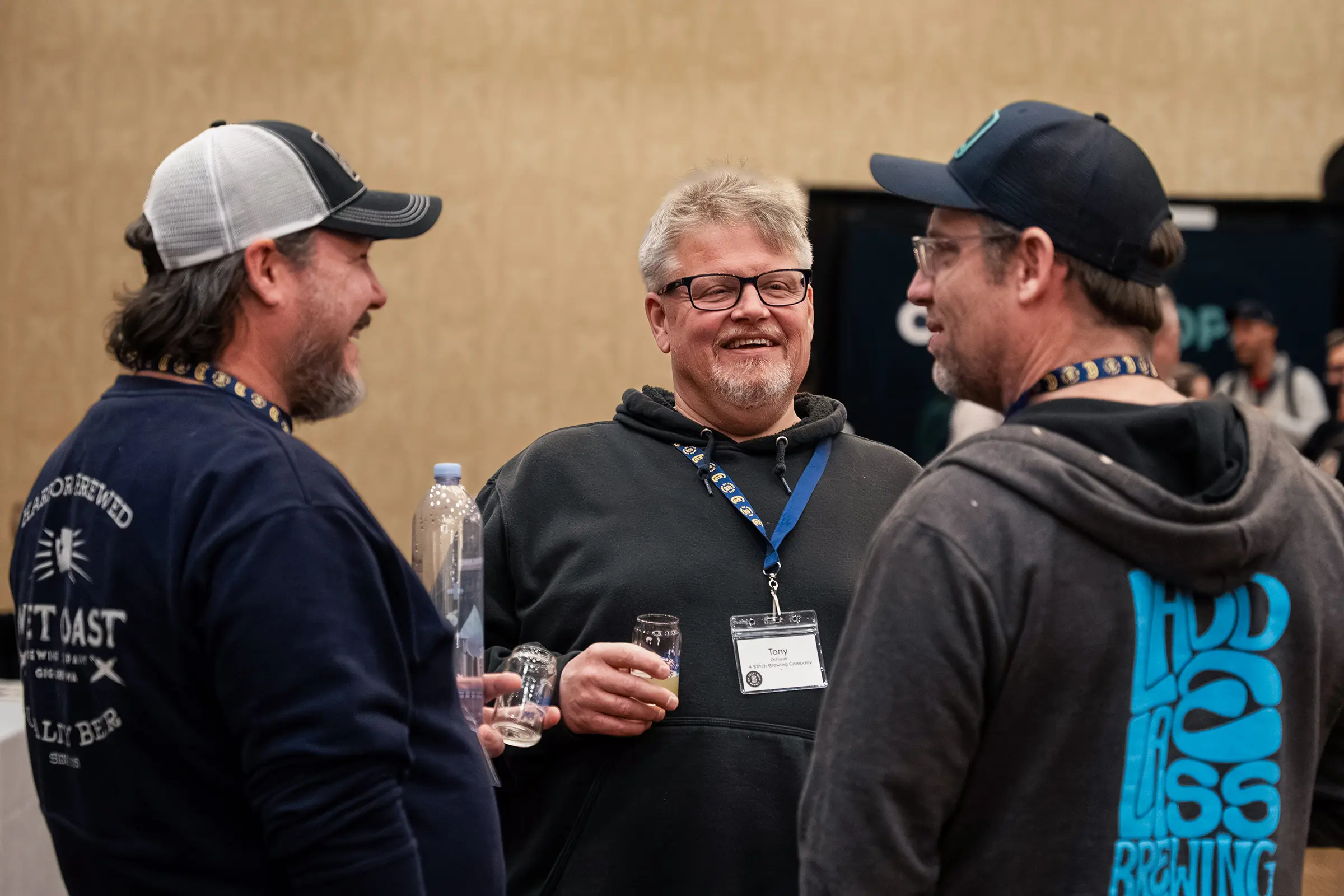 Group of attendees talking and holding drinks at summit