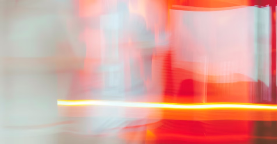 Abstract blurred image with streaks of red, orange, yellow, and light blue colors.