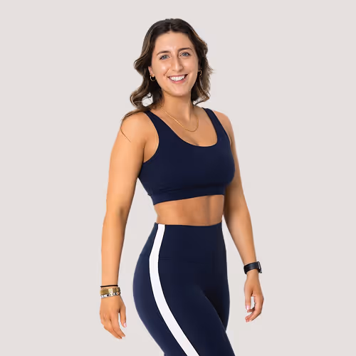 Smiling woman in navy blue athletic outfit with white side stripes, wearing bracelets and a fitness watch.