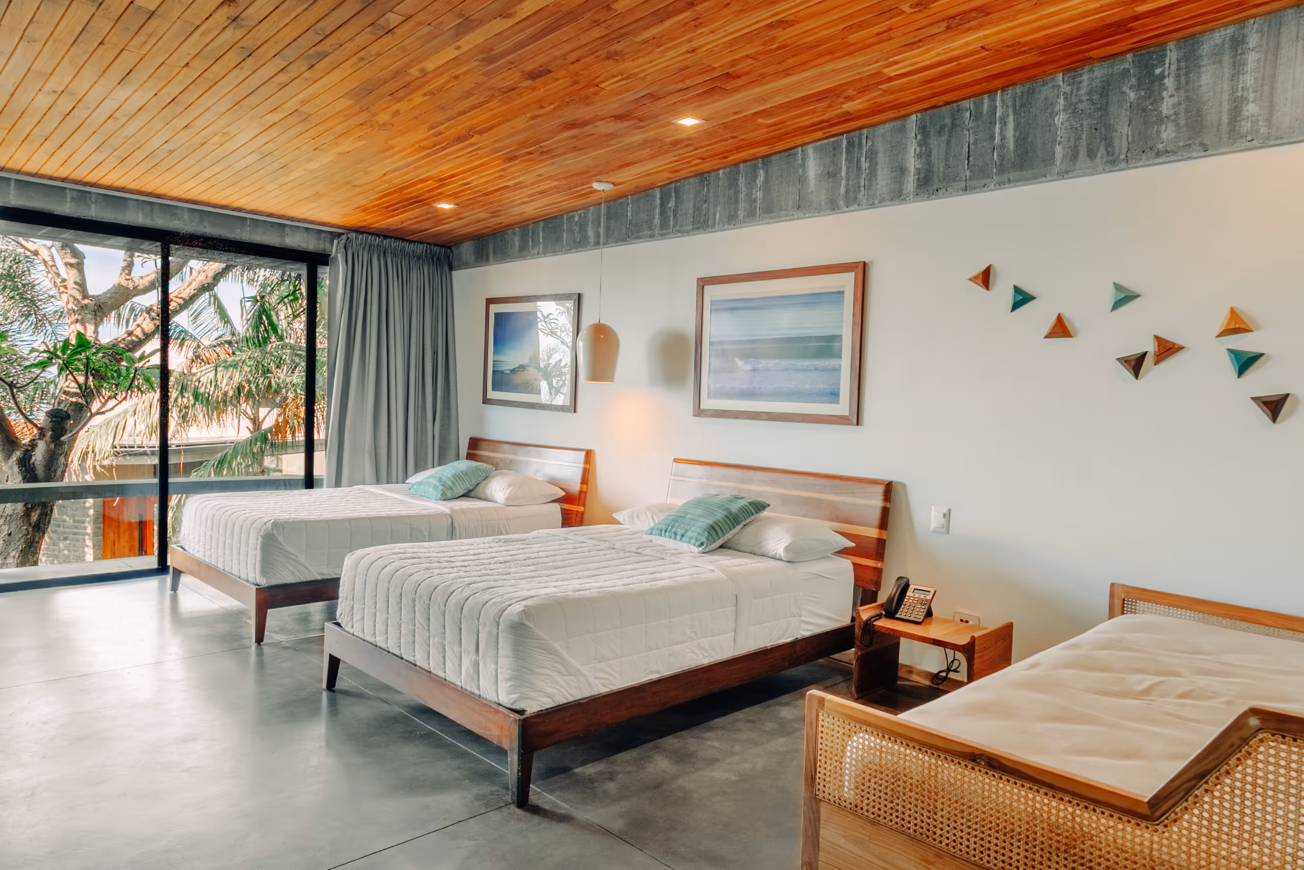 A bright room with a wooden ceiling and a garden view