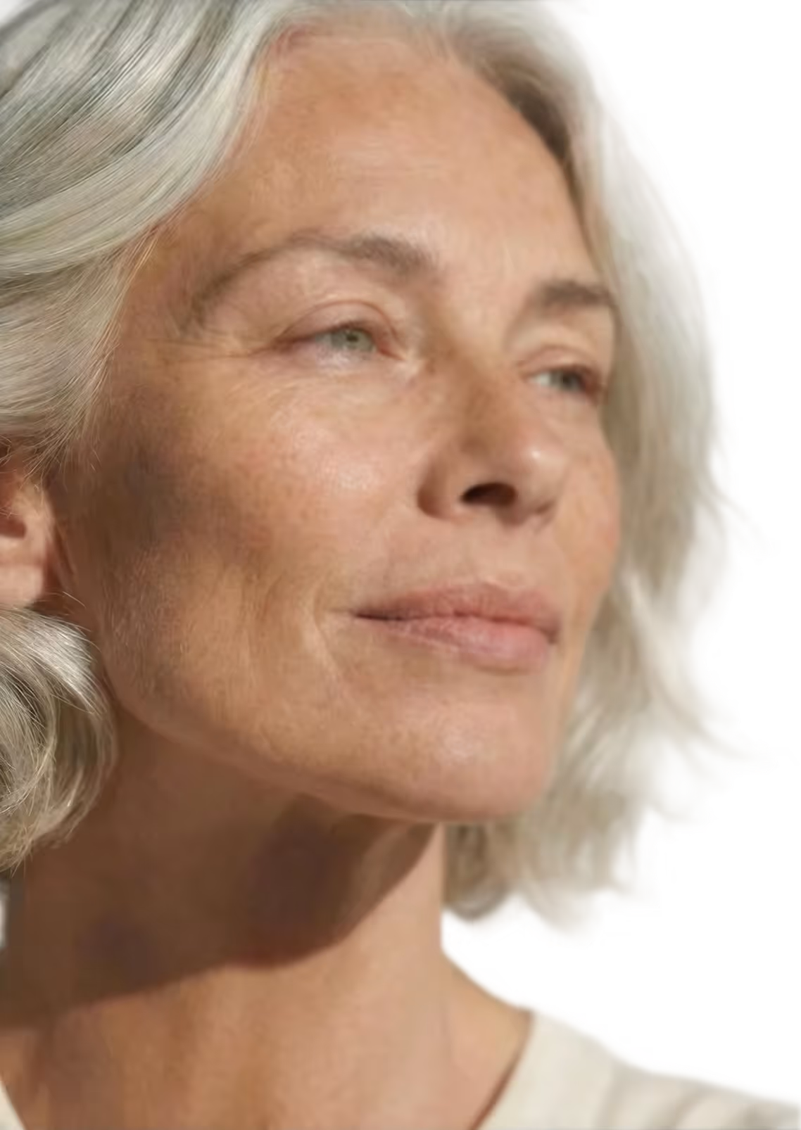 Close-up of a serene middle-aged woman with short gray hair looking slightly upward and to the side.