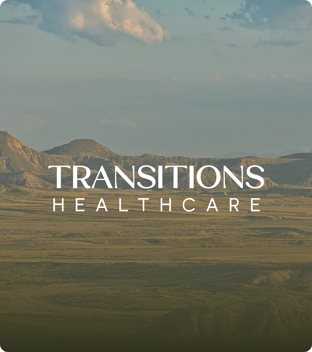 Scenic landscape of rolling hills and a partly cloudy sky with the text Transitions Healthcare overlaid.