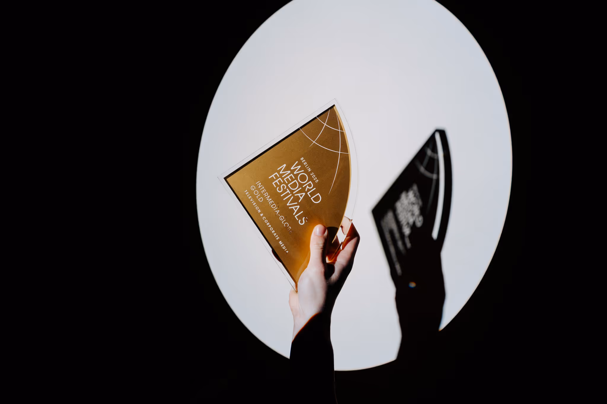 Krupni plan ruke koja drži prestižnu zlatnu nagradu "World Media Festivals Gold" s Berlina.
