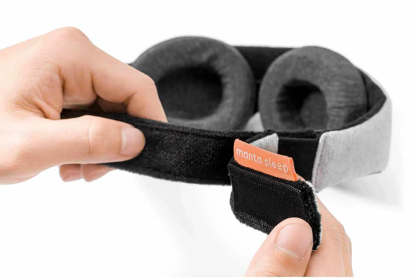 Hands adjusting the Manta Sleep Mask strap