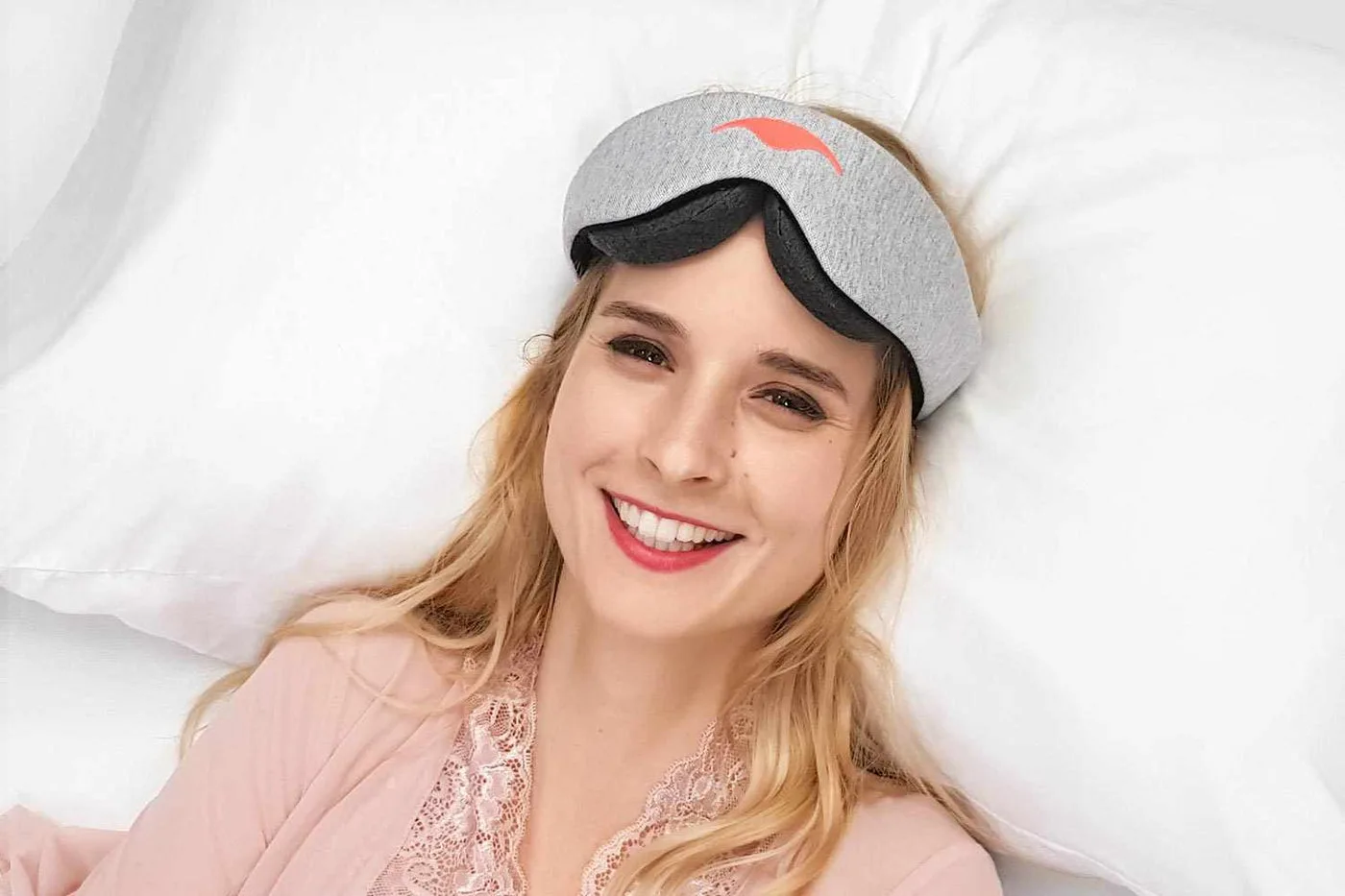 Woman resting on a pillow wearing the Manta Sleep Mask