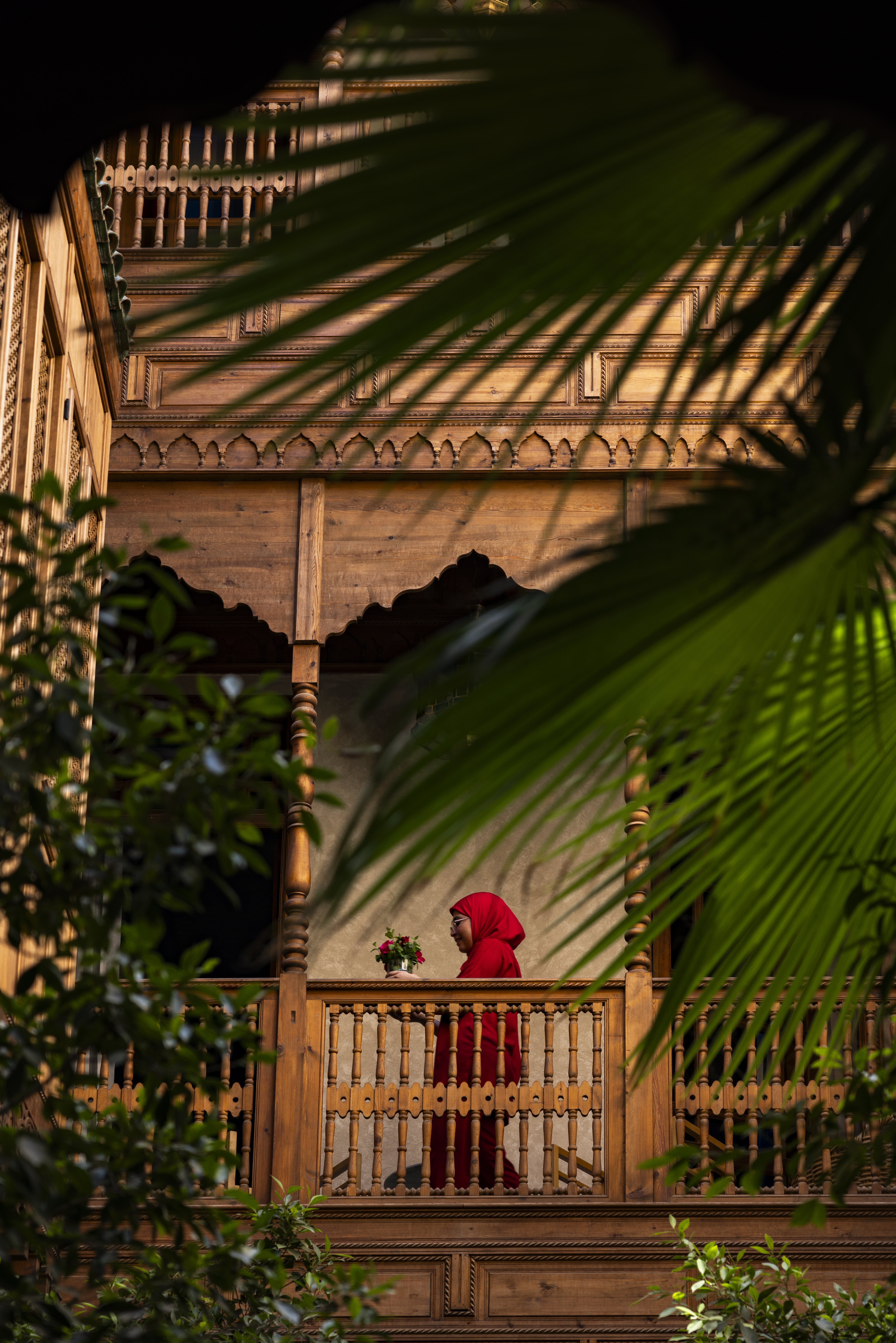 El Fenn — ornate wooden gallery with carved balcony, palm fronds