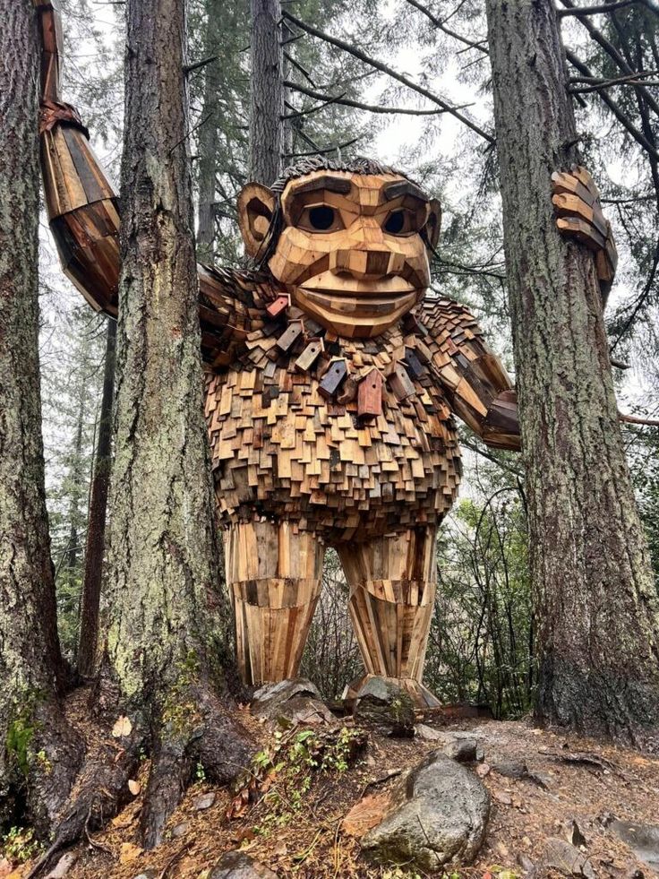 This may contain: a wooden sculpture in the middle of a forest