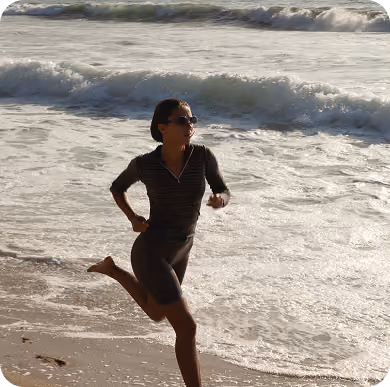 Mujer corriendo por la orilla del mar