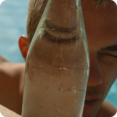 Botella de vidrio alzada contra el cielo