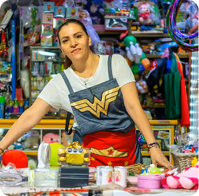 Comerciante con mandil de la Mujer Maravilla en su puesto de juguetes