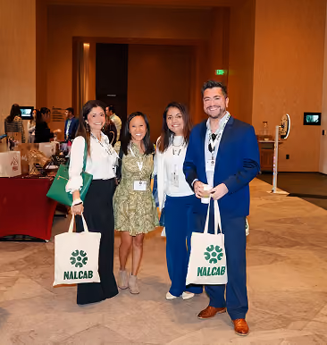 Conference attendees posing with NALCAB tote bags