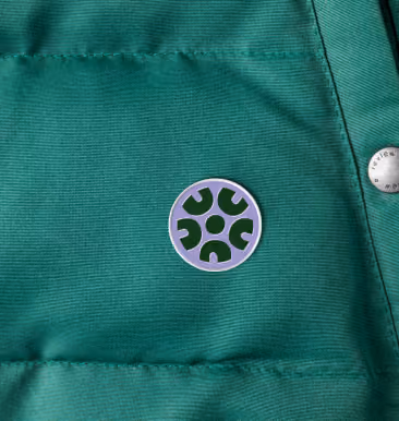 NALCAB enamel pin on a green jacket