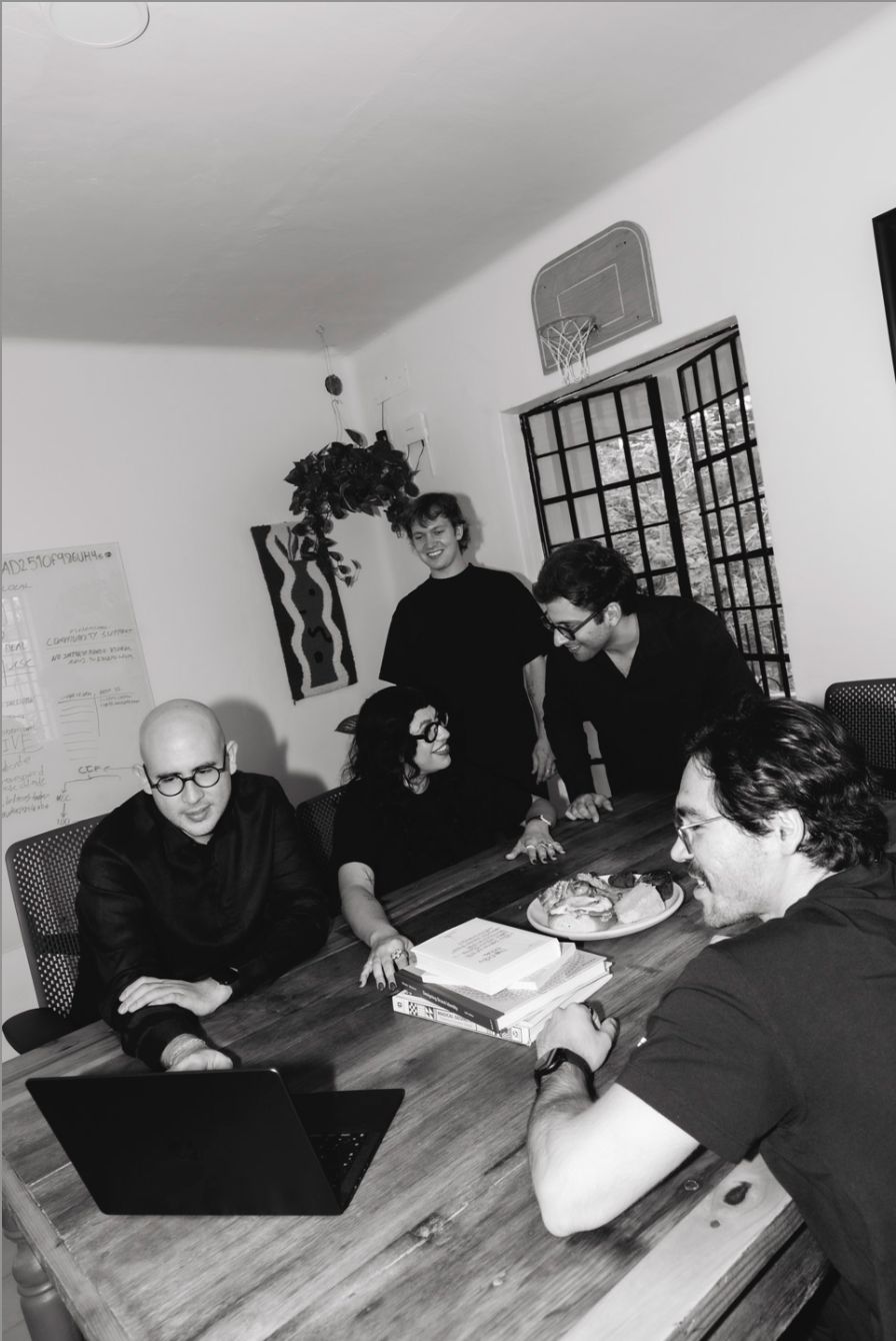 Black-and-white photo of the Calo team working around the table