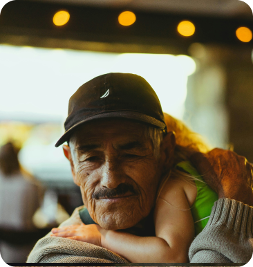 Older man in a cap embraced, in golden light