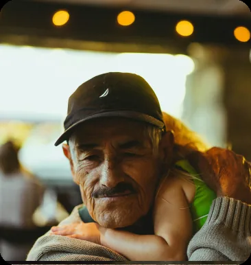 Older man in a cap embraced, in golden light