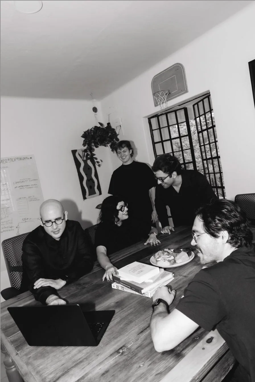 Black-and-white photo of the Calo team working around the table