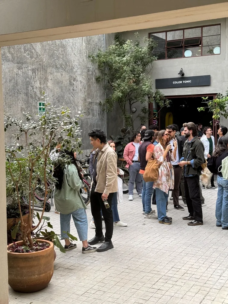 Crowd gathered in a gallery courtyard at a Calo artist residency opening