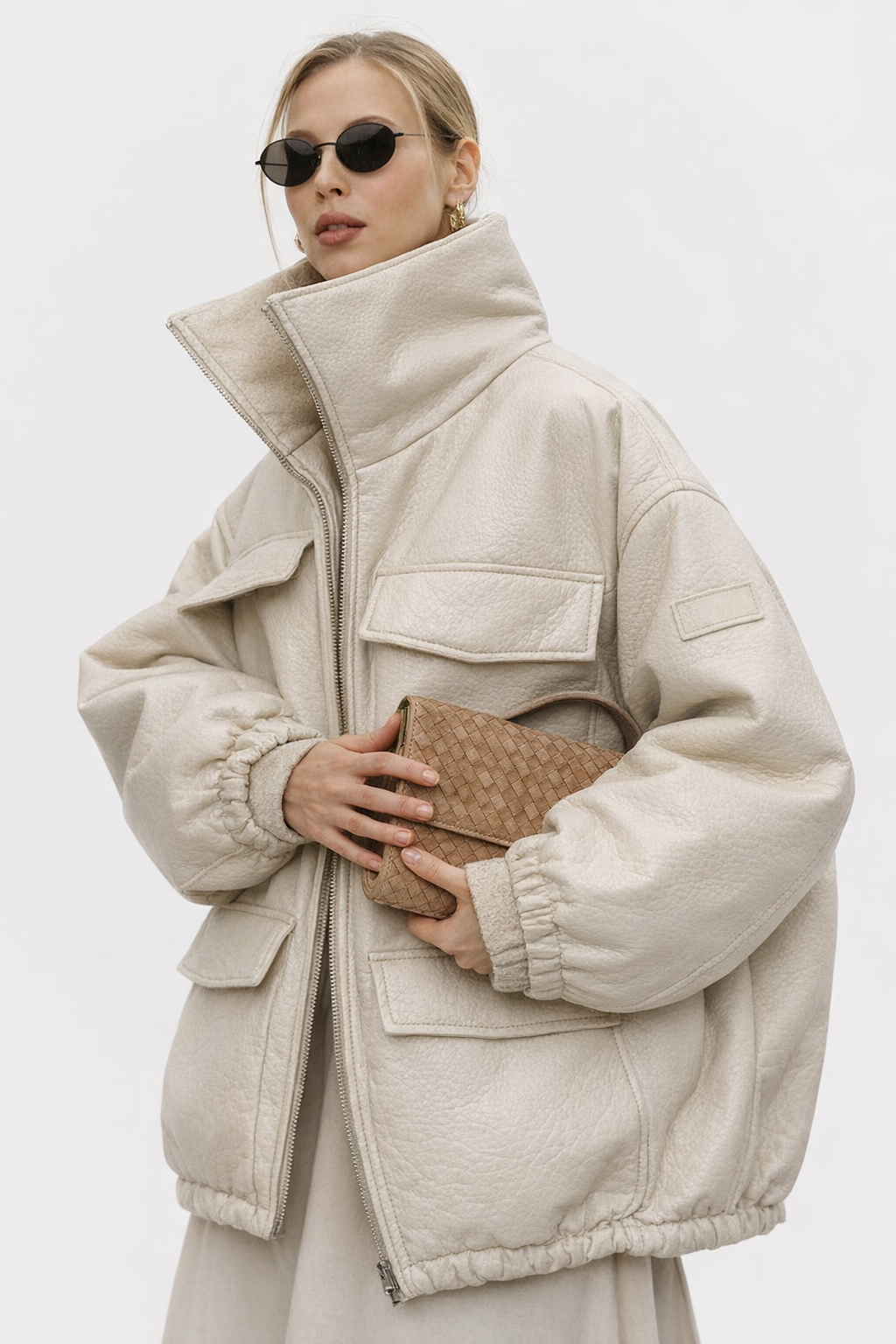 Close view of olive suede KMRO mule showing apron stitching, strap detail, and textured suede upper while held in hand.