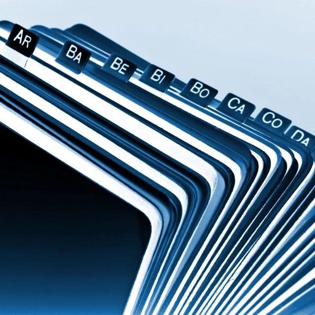 Close-up of a stacked index card holder with visible tabs labeled AR, BA, BE, BI, BO, CA, CO, and DA.