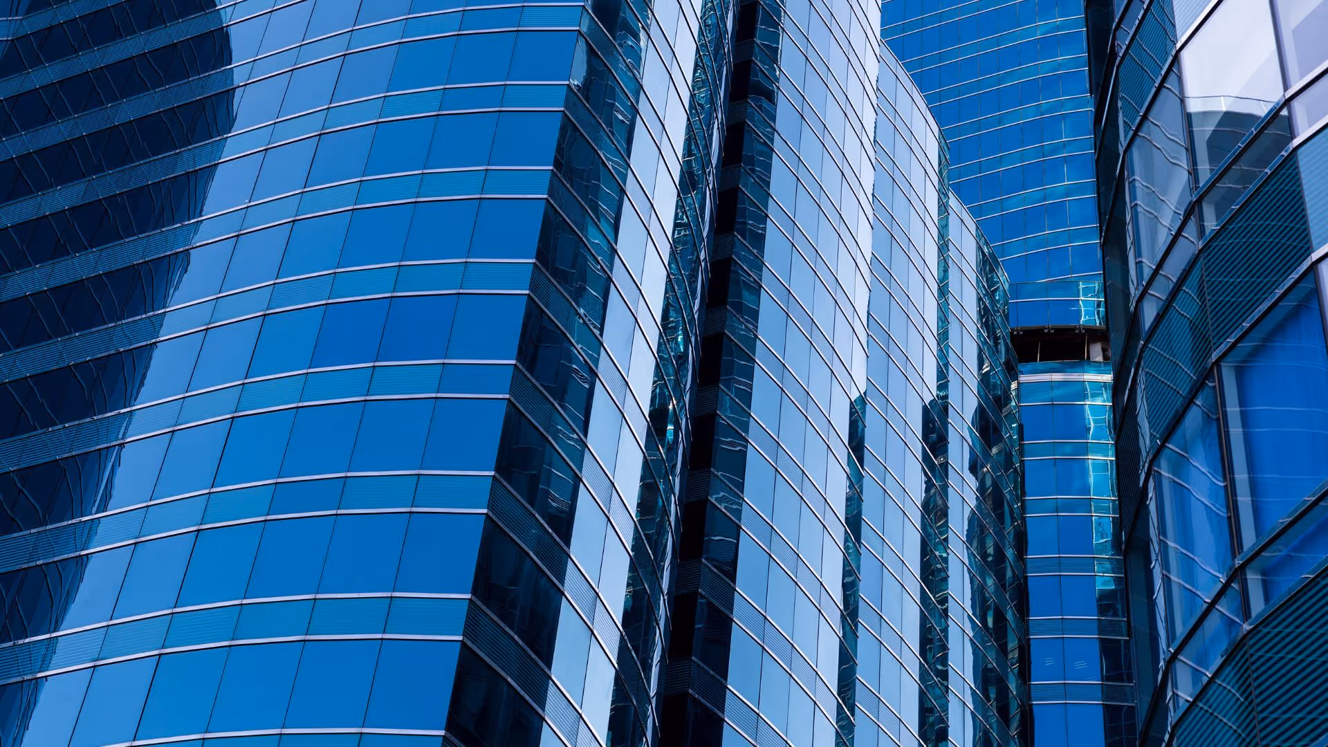 Close-up view of modern blue glass skyscrapers with reflective windows.