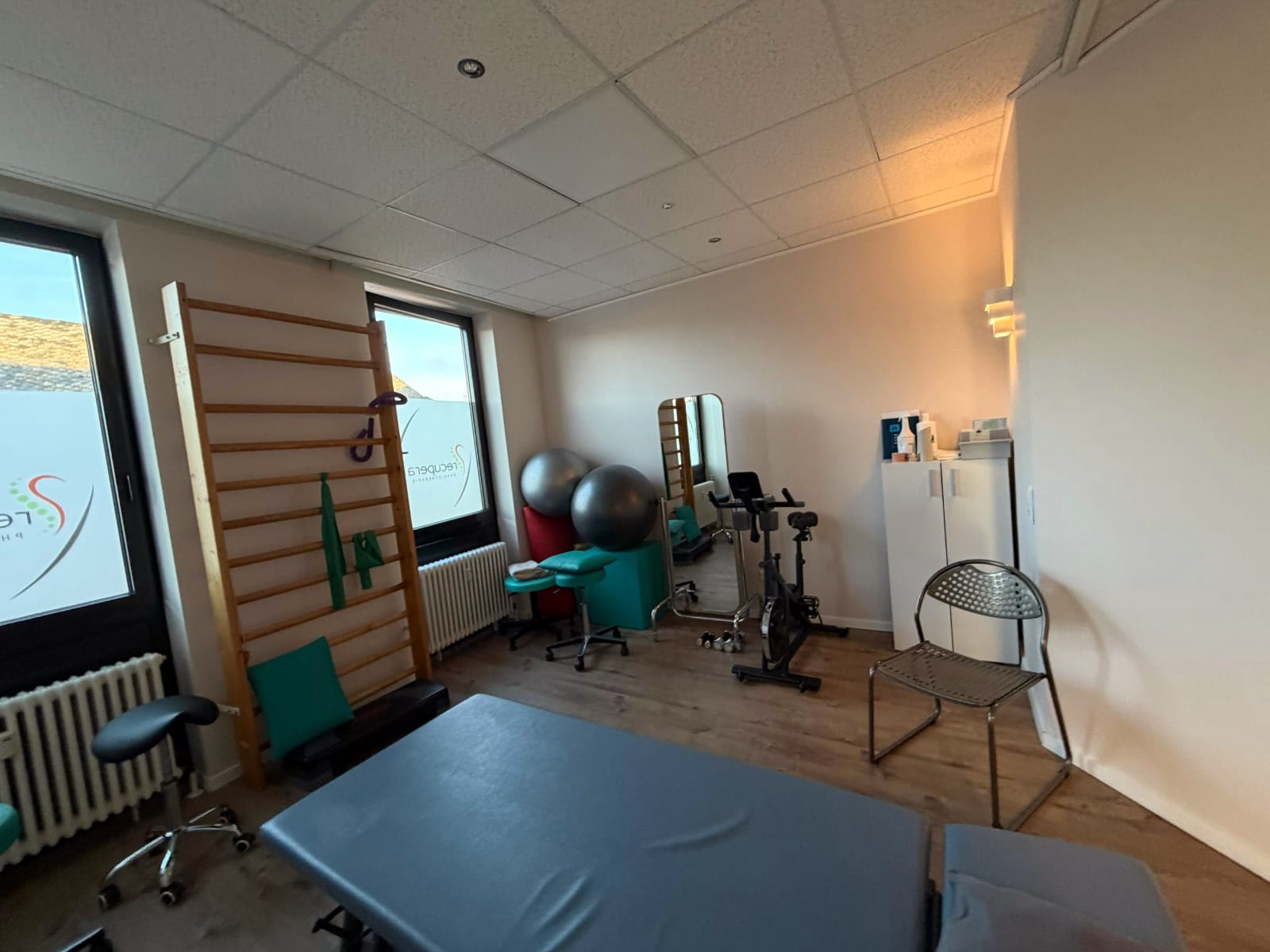 Trainingsraum mit Sprossenwand, Gymnastikbällen, Therapieliege und Trainingsgerät