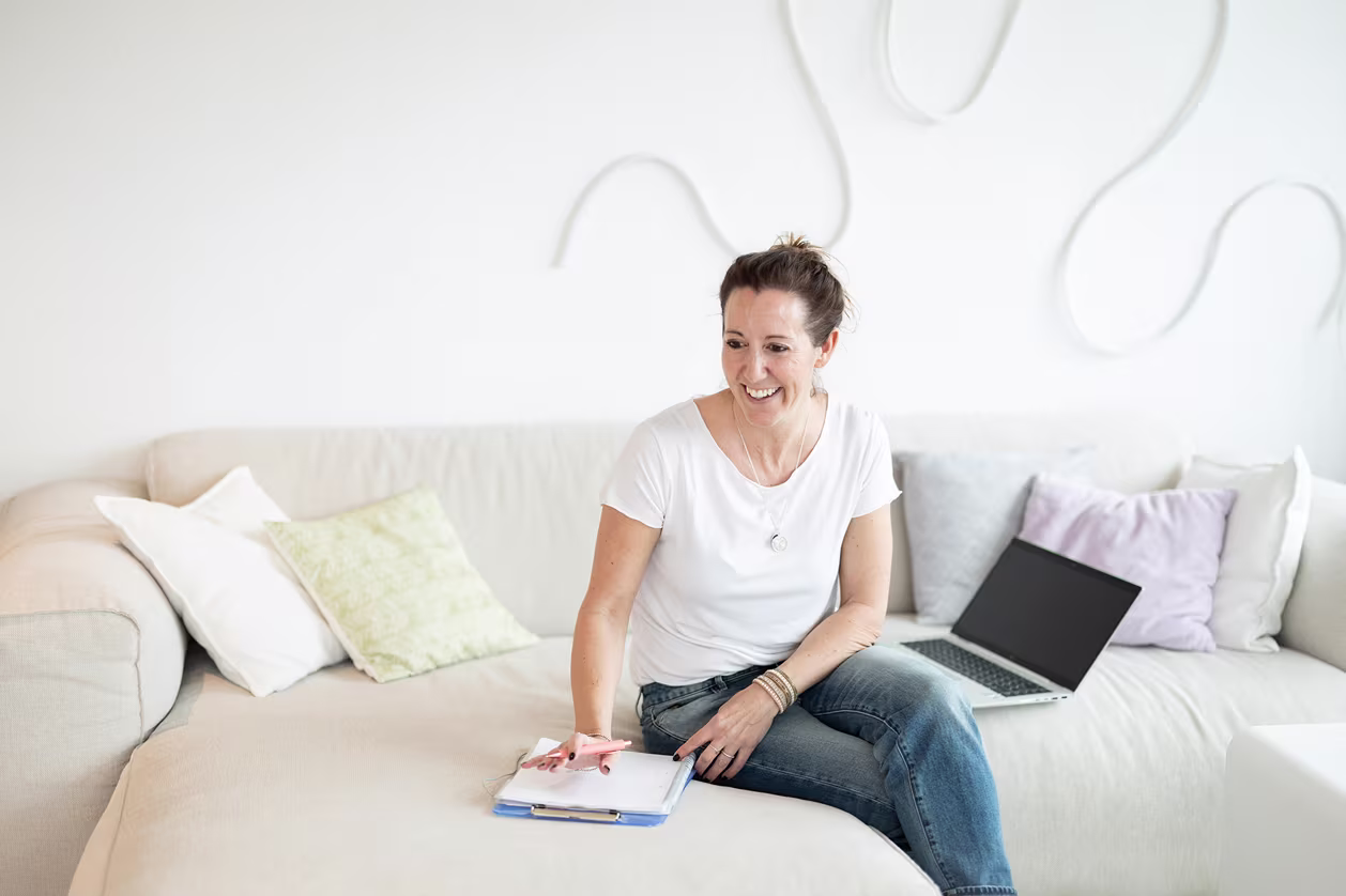 Frau sitzt entspannt auf Sofa – Coaching Umgebung