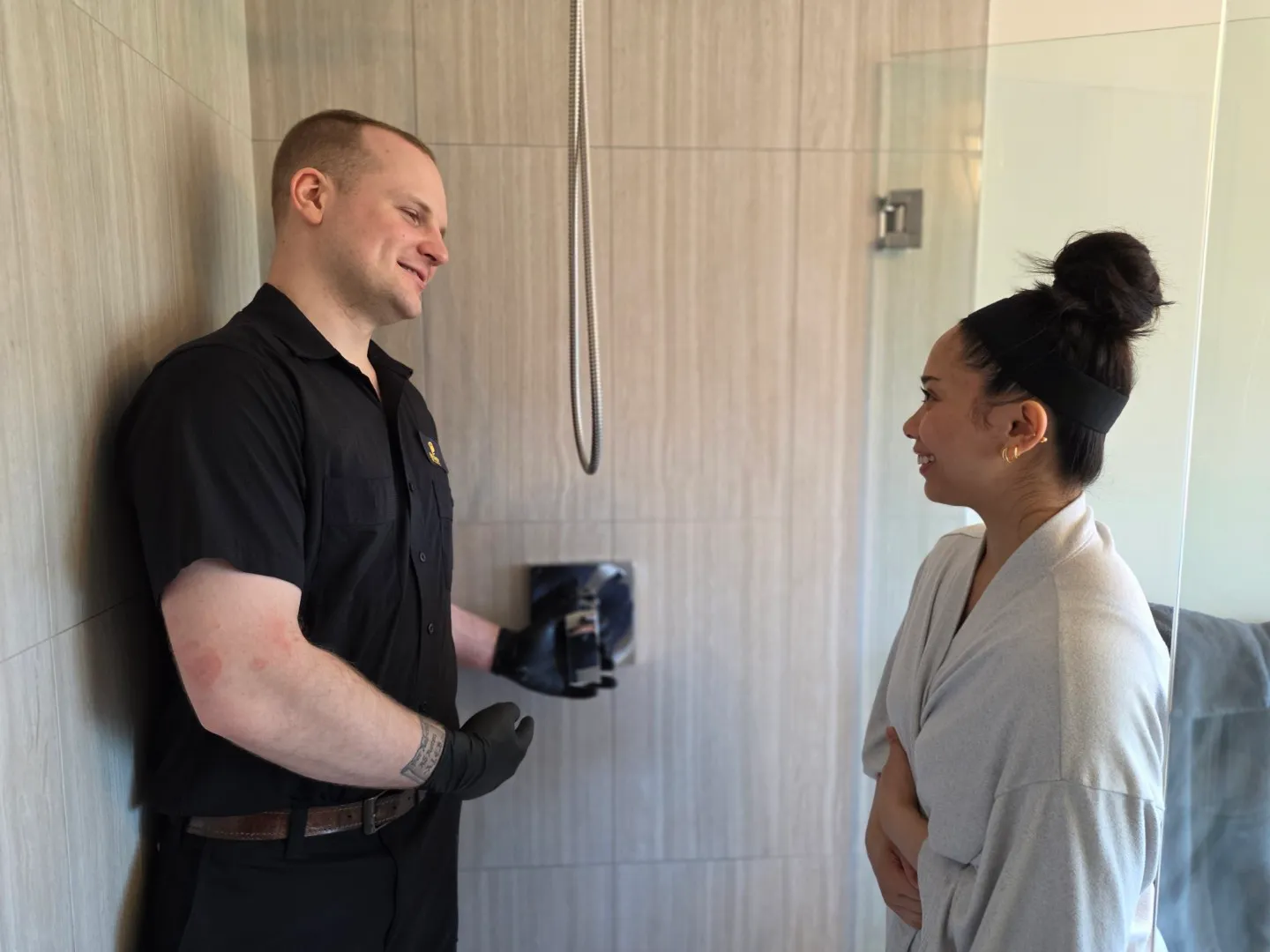 The Crazy Plumber technician explaining completed shower installation to a satisfied homeowner in Port Coquitlam.