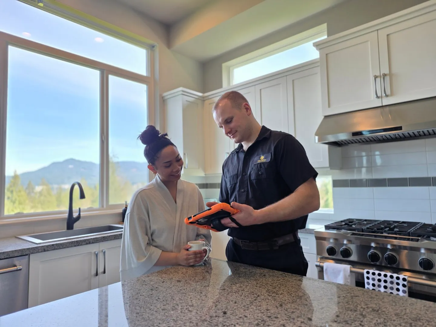 The Crazy Plumber technician reviewing a plumbing work order with a homeowner in their kitchen in Port Coquitlam - transparent, honest plumbing estimates and service in the Lower Mainland, BC