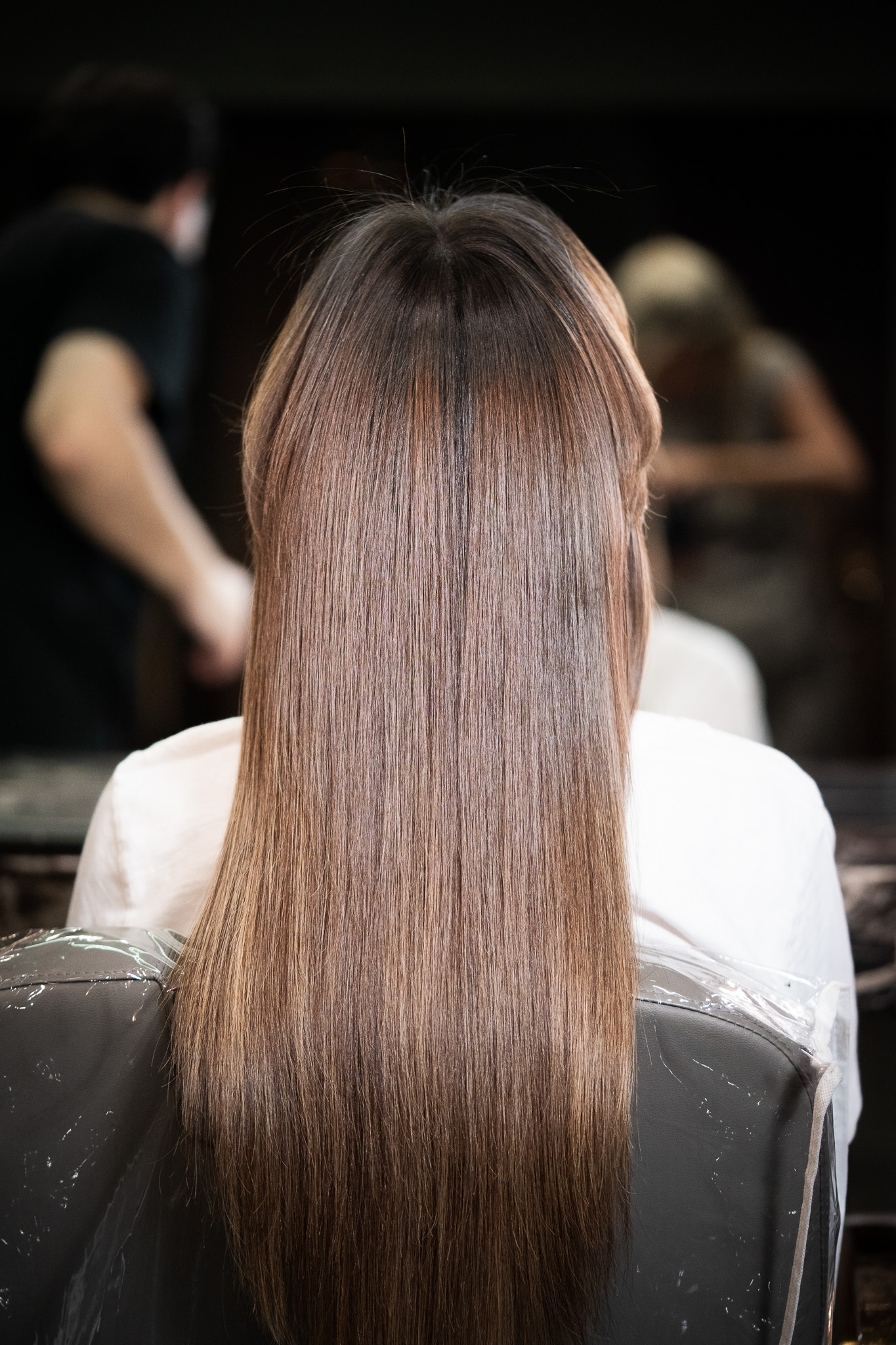 Stylist combing glass-like shiny hair after March14's Insta Shine reflective treatment in Dubai
