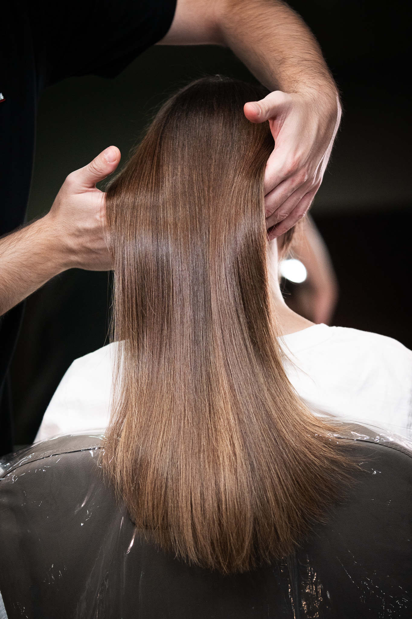 Hands cradling glossy, light-reflective hair after the Insta Shine treatment at March14 Beauty Residence Dubai