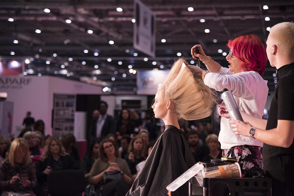 Professional hairdressing demonstration on stage, illustrating beauty salon industry growth in 2026