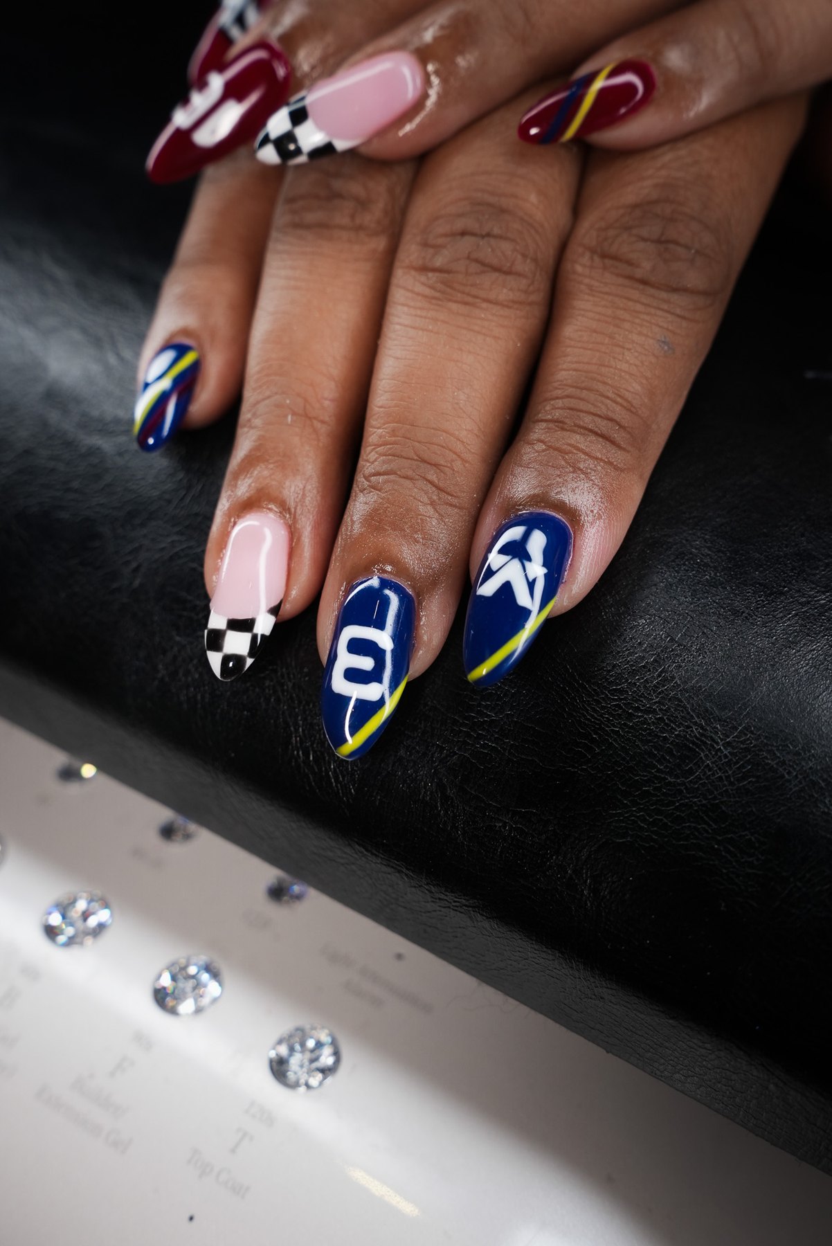 Max Verstappen number 3 F1 nail art in Dubai at March14: navy nails with yellow pinstripe and chequered flag French tip