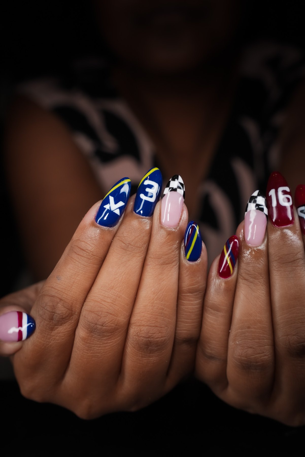 F1 nail art Dubai close up with Max Verstappen number 3, Charles Leclerc number 16 and chequered flag French tips on almond nails