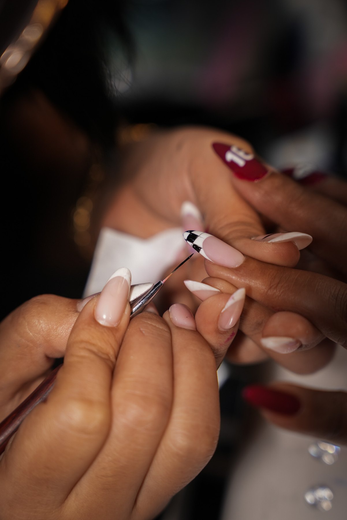 Chequered flag nail art being painted square by square at March14 Nails Theatre in Dubai