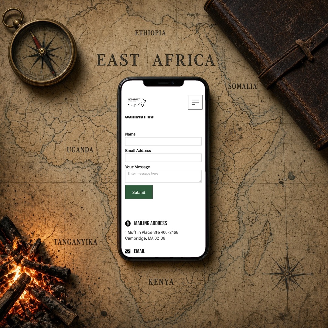 Roosevelt Africa Trail contact page on a phone lying on a vintage map of East Africa by a campfire, showing layout and design