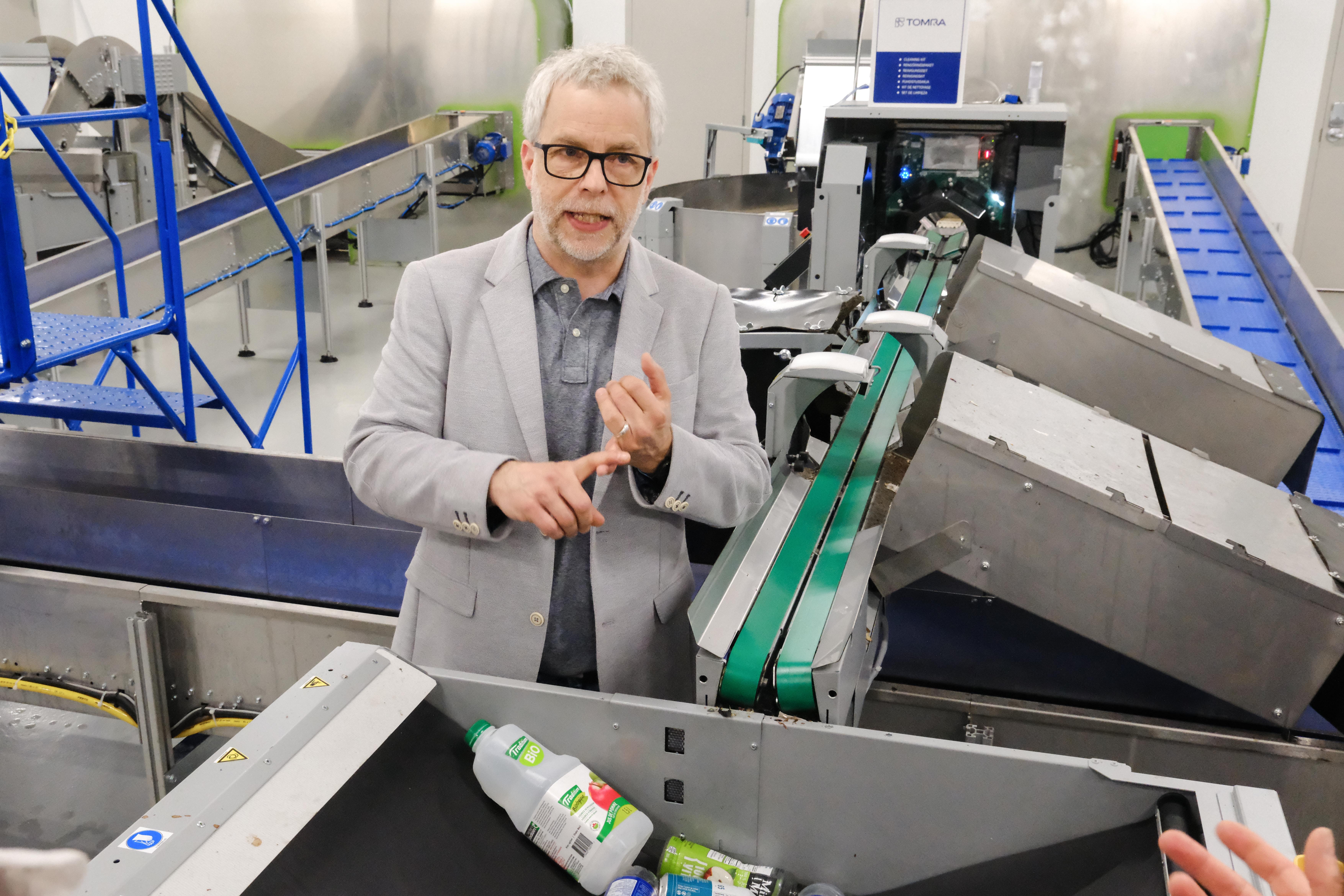 A facility host explaining container sortation equipment to the group