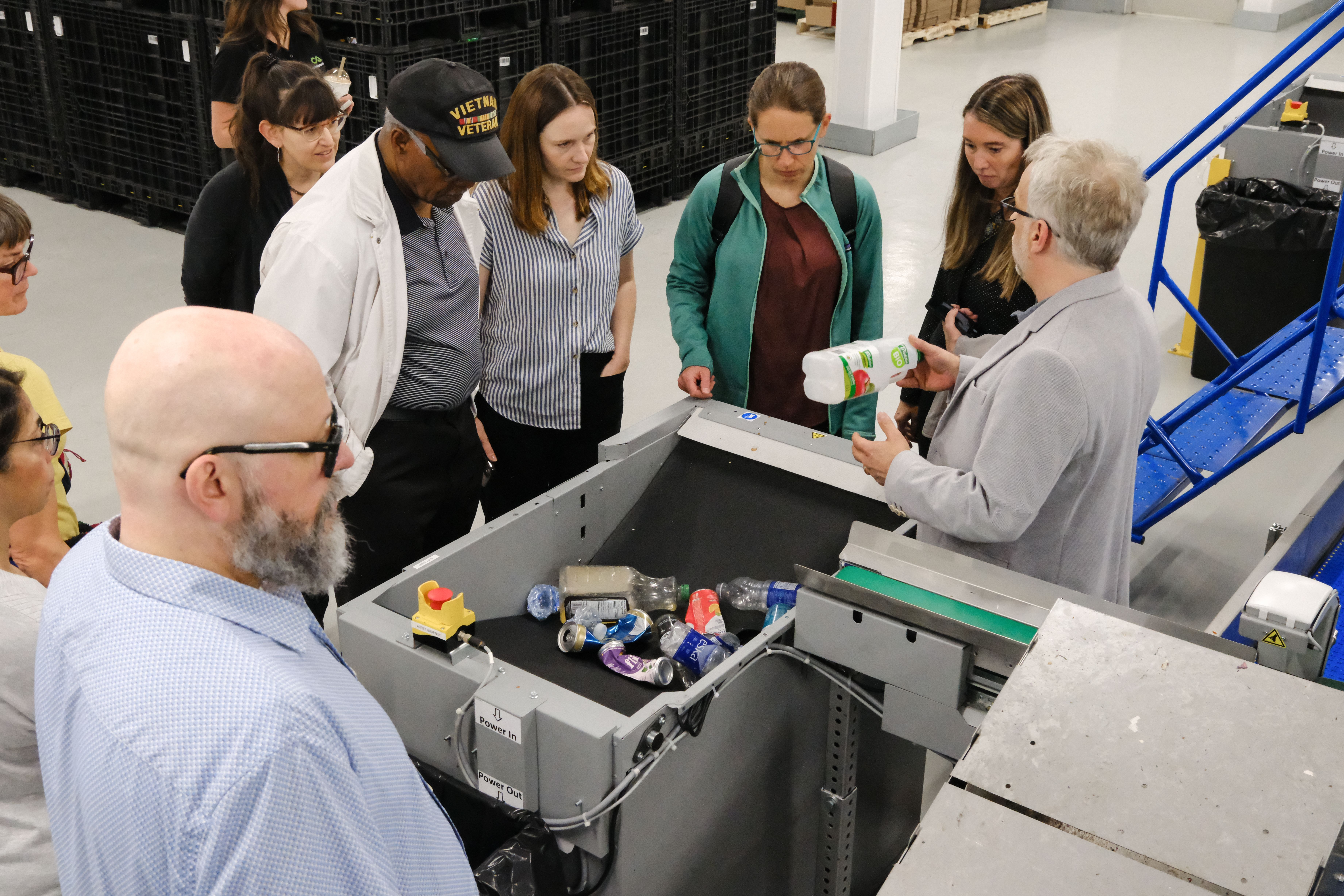 Participants gathered around a sorting station examining recovered material