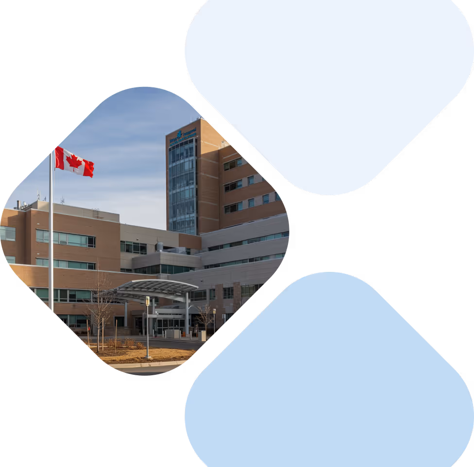 Multi-story medical center building with a Canadian flag flying in front under a clear sky.