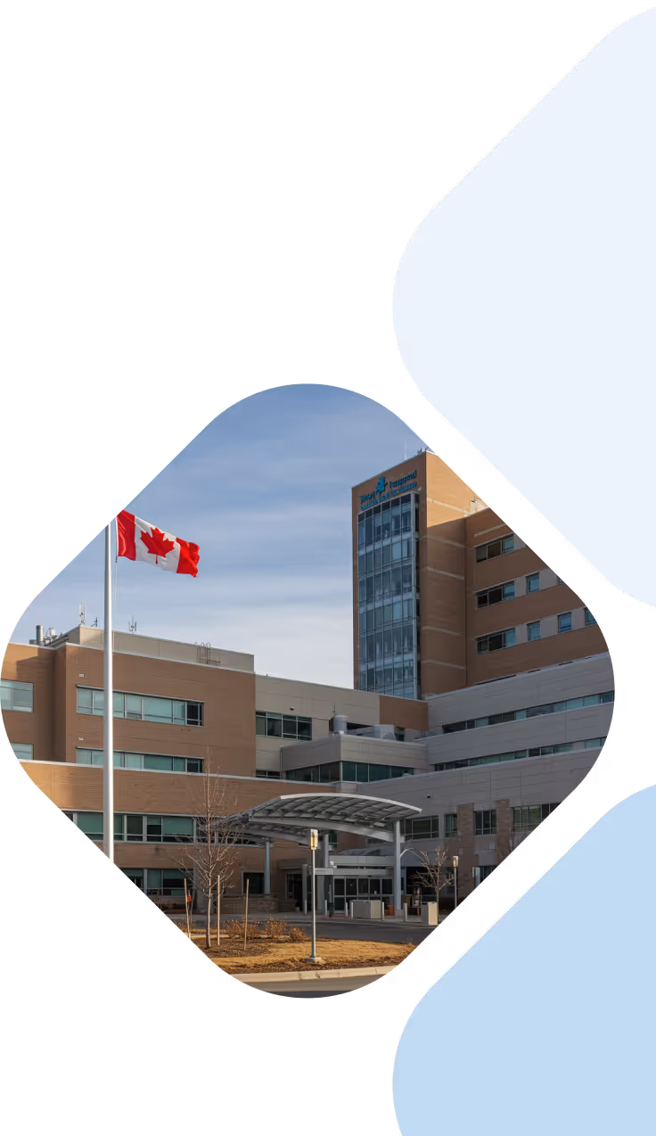 Multi-story medical center building with a Canadian flag flying in front under a clear sky.